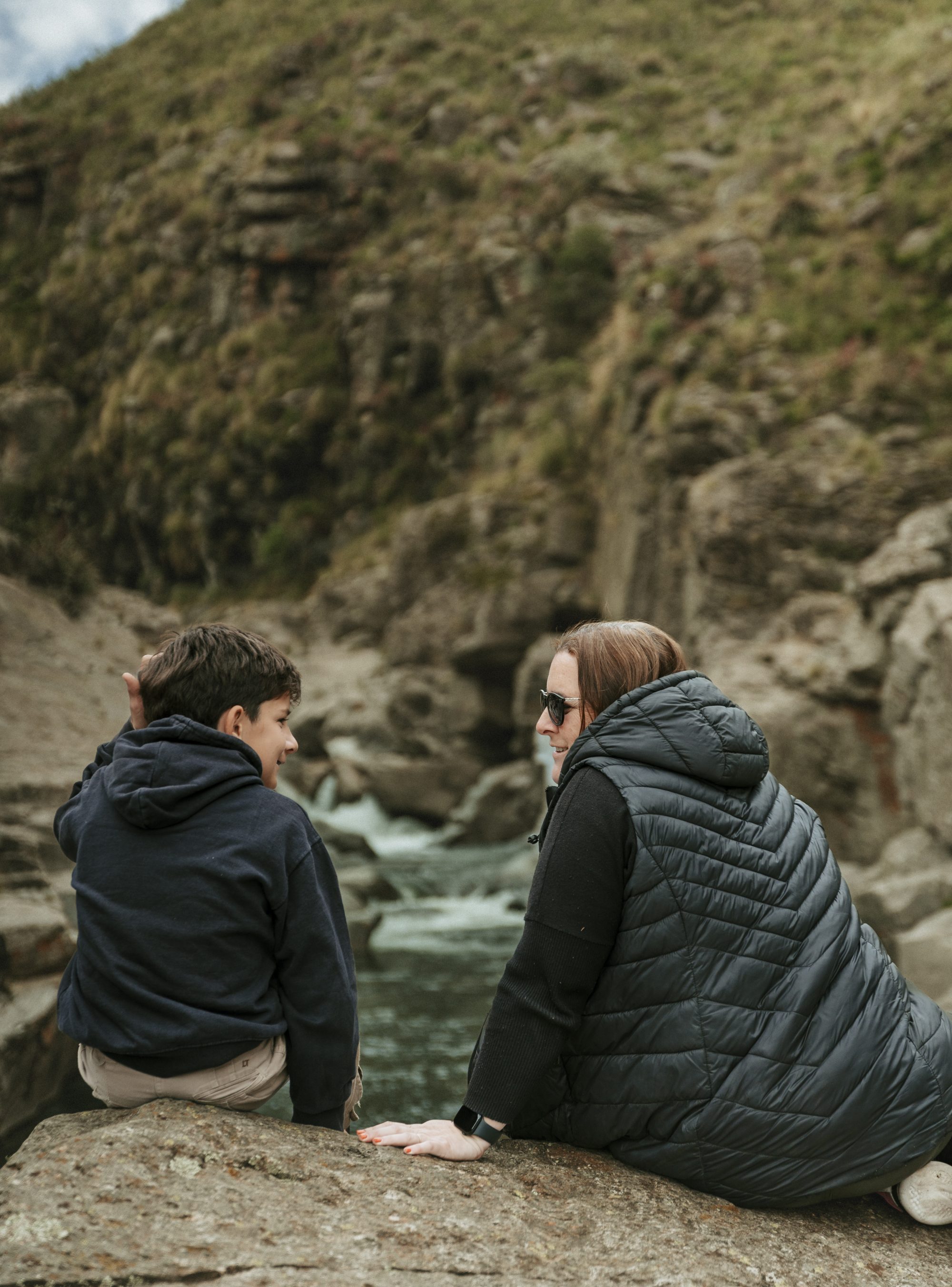 Una pareja descansa sobre las rocas del río