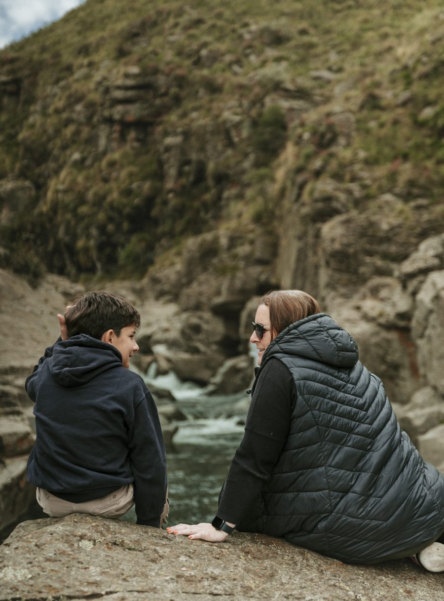 A couple rests on the river rocks